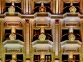 Illuminated architectural facade with classical columns and glowing patterned balcony lights on a historic city building.